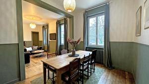 a dining room with a table and a living room at Domaine de juriol - la demeure in Le Palais-sur-Vienne