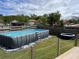 a swimming pool in a yard with a fence at Le cap in Lit-et-Mixe