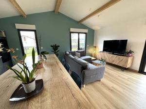 a living room with a large wooden table and a couch at Le cap in Lit-et-Mixe