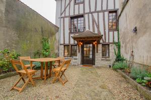 a table and chairs in front of a building at L'agapanthe in Bar-sur-Aube