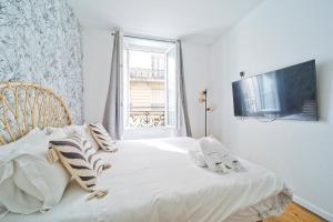 ein Schlafzimmer mit einem weißen Bett und einem Fenster in der Unterkunft Magnifique appartement parisien in Paris