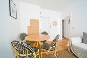 ein Tisch und Stühle in einem Wohnzimmer mit einer Couch in der Unterkunft Magnifique appartement parisien in Paris