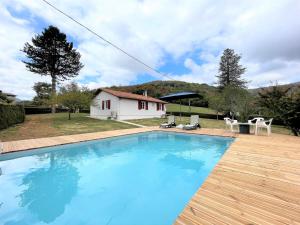 a large blue swimming pool in front of a house at Gure doya in Ibarrolle