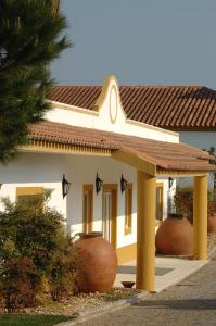 une maison avec deux grands vases devant elle dans l'établissement Vila Gale Alentejo Vineyard - Clube de Campo, à Albernoa