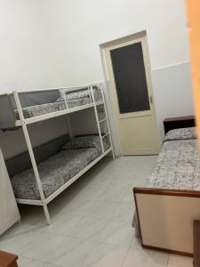 Ce dortoir comprend 2 lits superposés et une porte. dans l'établissement Appartamento Gemma, à Catane