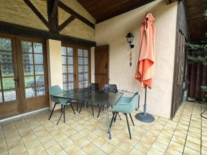 a dining room with a table and chairs and an umbrella at Le pin franc in Azur