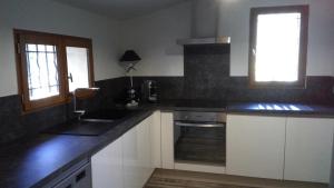 a kitchen with white cabinets and a sink and a window at Le cabanon du capelan in La Motte
