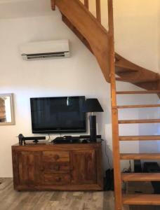 sala de estar con TV de pantalla plana y escalera en Le cabanon du capelan, en La Motte