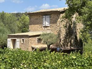 una casa de piedra con una ventana en un campo en Le cabanon du capelan, en La Motte