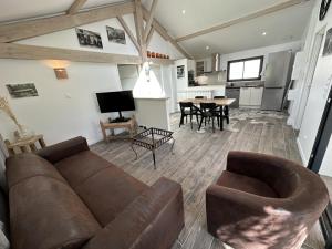a living room with a couch and a table at La maison poulet in Soustons