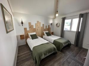 two beds sitting in a room with a window at La maison poulet in Soustons +21 photos