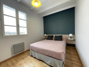 a bedroom with a bed and a wall with a window at Ekialde in Ainhoa