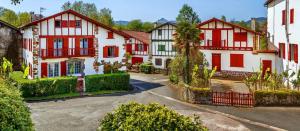 a row of white and red houses on a street at Ekialde in Ainhoa