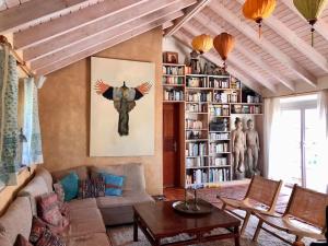a living room with a couch and a book shelf at Casa Swagatam in Aljezur