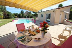 a table with food and flowers on a patio at Les carpes à limoges in Limoges