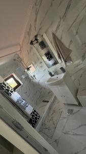 a marble bathroom with a sink and a mirror at Vila Bianca in Mangalia