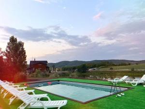 a swimming pool with lawn chairs and a swimming poolvisorvisorvisor at Mountain Lake JBS in Focşani
