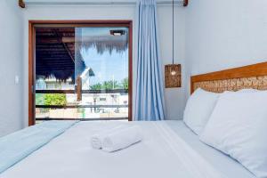a bedroom with a white bed and a window at Casa piscina privativa e vista-mar - Milagres in Passo de Camarajibe +26 photos