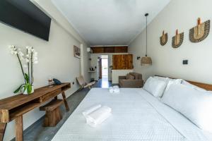 a bedroom with a large white bed and a couch at Elion Seaside Resort by Anayia All Inclusive Resorts in Eretria +62 photos