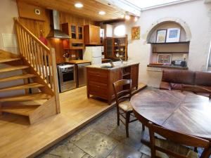 een keuken met een tafel en een trap in een kamer bij Le gite du barbe in Biaudos