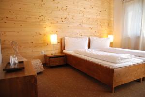 1 dormitorio con 1 cama y pared de madera en Pension Iara, en Arieşeni