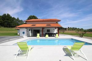 a swimming pool with two chairs and a house at Bordazarria in Juxue