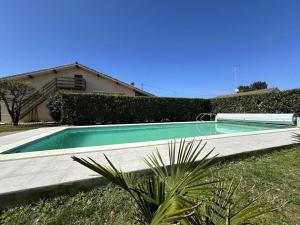 a swimming pool in the yard of a house at Les tilleuls in Soustons