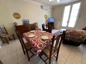 a dining room with a table and chairs and a television at Les tilleuls in Soustons