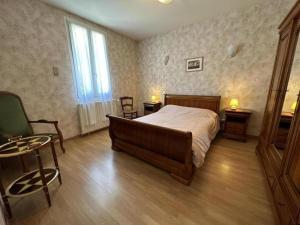 a bedroom with a bed and a table and chairs at Les tilleuls in Soustons +13 photos