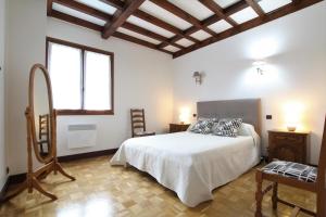 a white bedroom with a bed and a window at Iparla in Urrugne