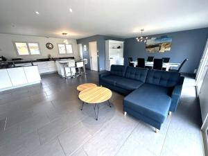 a living room with a blue couch and a table at La villa lou miqueou in Lit-et-Mixe