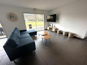 a living room with a blue couch and a table at La villa lou miqueou in Lit-et-Mixe