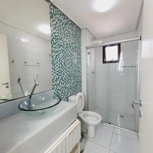 a bathroom with a sink and a toilet and a shower at Paraiso no Guarujá Enseada - Piscina - Ar Condicionado - WIFI - Garagem in Guarujá