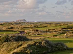 a view of a golf course with a mountain in the background at Ballyliffin Hotel in Ballyliffin