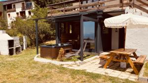 dom ze stołem piknikowym i parasolem w obiekcie Can Sansa Appartement 4* jacuzzi maison pyrénéenne w mieście Font-Romeu-Odeillo-Via