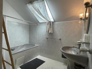 Lucq-de-BéarnにあるPetit gite lavieのバスタブと洗面台のあるバスルーム +14枚の写真