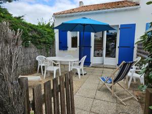 a patio with a table and chairs and an umbrella at Maisonnette à 150m de la plage, parking privé - FR-1-476-8 in La Faute-sur-Mer