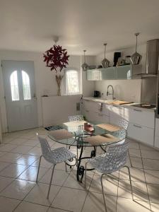 eine Küche mit Tisch und Stühlen in einem Zimmer in der Unterkunft DOMAINE DE GUILLEMIN in Saint-Louis-de-Montferrand