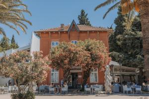 a building with tables and trees in front of it at Le Petit Chateau in Bar