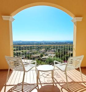 due sedie e un tavolo su un balcone con vista di Golf & Sea Residence Is Molas a Pula
