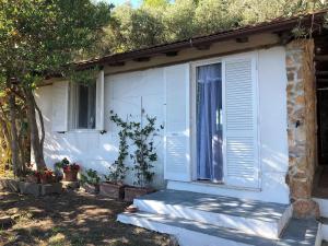 a white house with a door and a window at Splendid cottage on Tuscan Sea in Porto Santo Stefano
