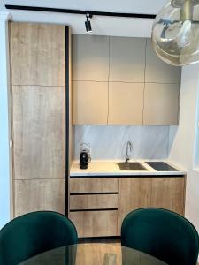 a kitchen with a sink and two green chairs at Apartments Mrdak in Bar