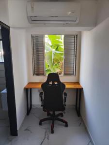 a desk in a room with a chair in front of a window at 11suites casa Suite#4 in Caraguatatuba