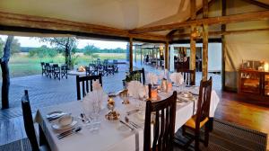 a dining room with white tables and chairs at Rhino Walking Safaris in Skukuza