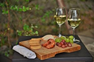 a cutting board with cheese and wine glasses on a table at Rhino Walking Safaris in Skukuza