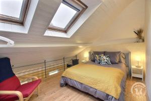 a bedroom with a bed in a attic with windows at De kerloic in Ploumilliau