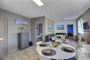 a living room with a table and a couch at Les hortensias in Louannec