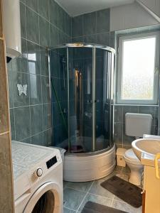 a bathroom with a shower and a toilet and a sink at Parkside Cozy Retreat in Pristina +14 photos