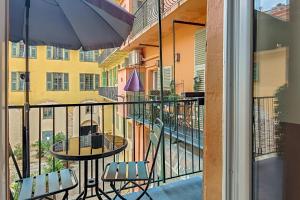 a balcony with a table and chairs and an umbrella at Aparthotel AMMI Vieux Nice in Nice