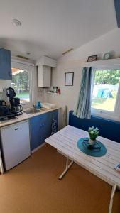 a small kitchen with a table and a table sidx sidx sidx sidx at Bungalow bord de mer in Les Mathes